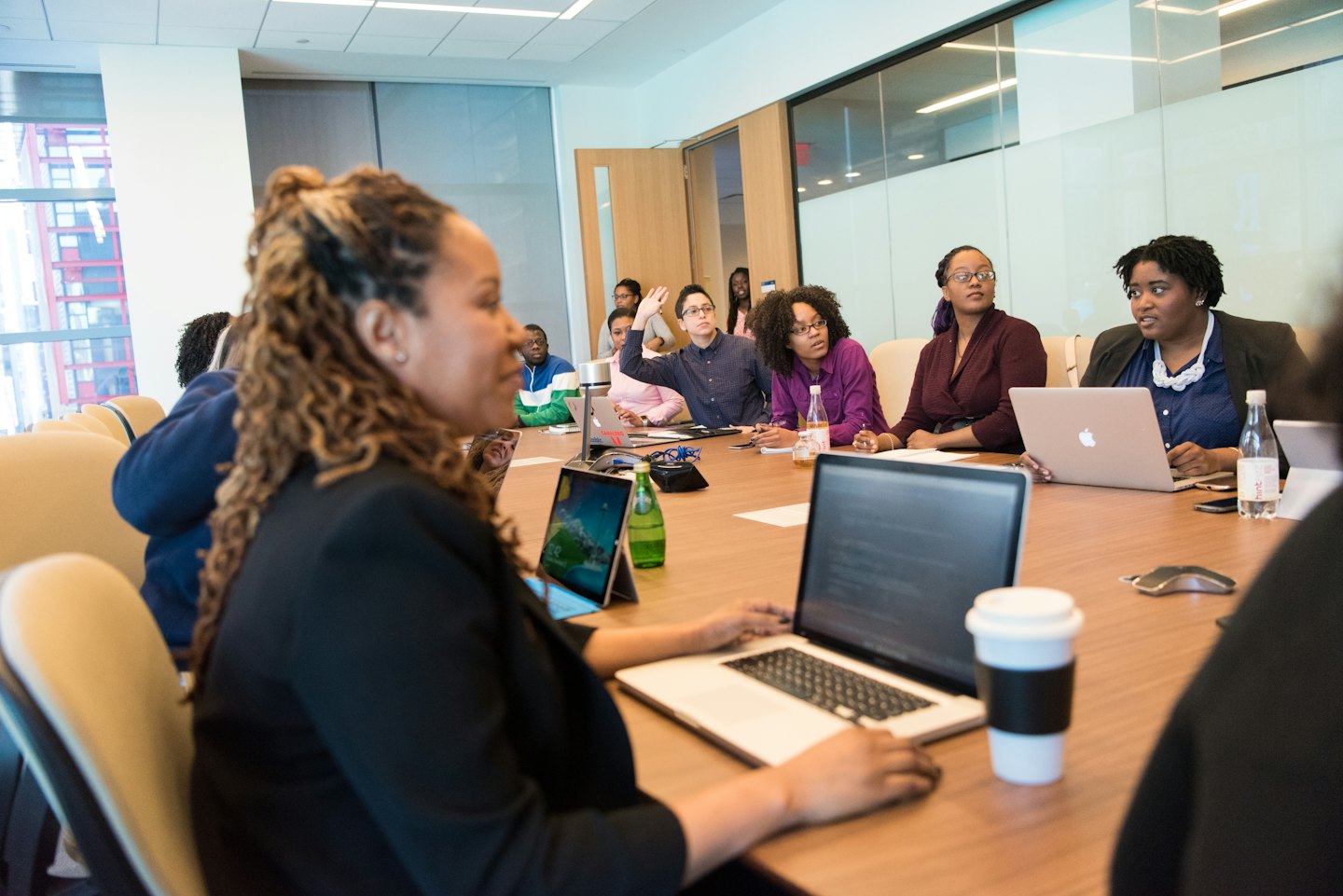 Diverse professionals in a meeting around a conference table.